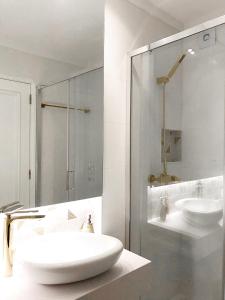 a white bathroom with two sinks and a shower at Casa Suyay Studio in Aveiro