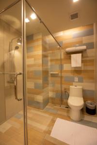 a bathroom with a toilet and a glass shower at Holiday Ao Nang Beach Resort, Krabi - SHA Extra Plus in Ao Nang Beach