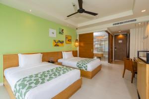 
a hotel room with two beds and two lamps at Holiday Ao Nang Beach Resort, Krabi - SHA Extra Plus Certified in Ao Nang Beach
