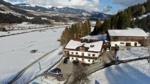 uma vista aérea de uma casa na neve em Fasserhof em Bramberg am Wildkogel