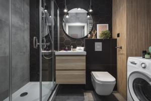 ein Badezimmer mit Waschbecken, Toilette und Spiegel in der Unterkunft TS New Town Apartments in Stettin + 42 Fotos