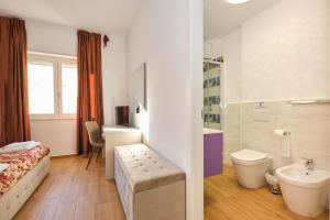 a bathroom with a bed a sink and a toilet at Piovella in Cagliari