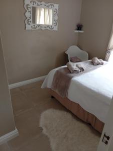 una camera da letto con un letto con specchio e un tappeto di Toscana Cottage a Port Elizabeth