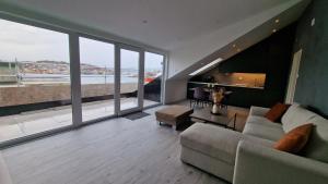 sala de estar con sofá y ventanas grandes en Lovely 2-bedroom loft with panoramic view. en Kristiansund