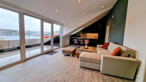 a living room with a couch and a large window at Lovely 2-bedroom loft with panoramic view. in Kristiansund +22 photos
