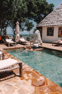 a person in a swimming pool at a resort at The Island - Pongwe Lodge in Pongwe