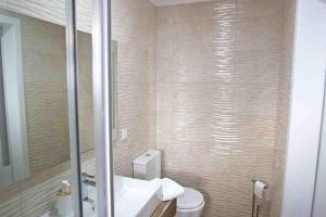 a bathroom with a toilet and a sink and a mirror at WATERS HOUSE STUDIO in Peniche