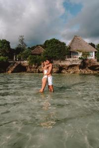 a man and a woman standing in the water at The Island - Pongwe Lodge in Pongwe