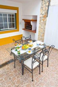 a glass table with chairs and fruit on it at WATERS HOUSE STUDIO in Peniche