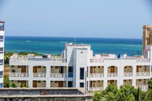 un edificio bianco con l'oceano sullo sfondo di Lux Suites Royal Family Apartment Nyali a Mombasa