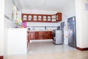 una cucina con armadietti in legno ed elettrodomestici in acciaio inossidabile di Lux Suites Royal Family Apartment Nyali a Mombasa