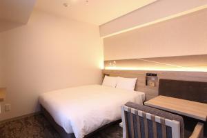 札幌市にある札幌ワシントンホテルプラザのベッドとベンチ付きの小さな部屋です。