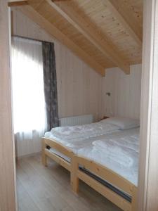 a bed in a room with a wooden ceiling at Ferienhaus Nr 17B2, Feriendorf Hagbügerl, Bayr Wald in Waldmünchen