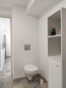 a white bathroom with a toilet and a sink at Les quatre chênes in Bauduen