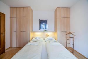 a bedroom with a large bed with wooden cabinets at Residence Pichler Apartment 6 in San Leonardo in Passiria