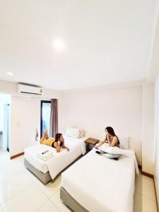 two women laying on beds in a hotel room at Don Muang Hotel in Bangkok