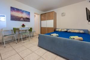 um quarto com uma cama, uma mesa e cadeiras em Apartmani Azur em Dramalj