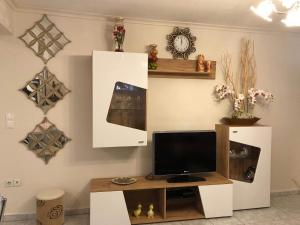 a living room with a tv and a desk with a monitor at VILLA ELENA 5***** in Vromerí