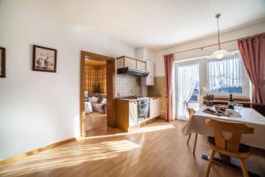 サン・レオナルド・イン・パッシーリアにあるResidence Pichler Apartment 8のテーブルとキッチンのあるリビングルーム