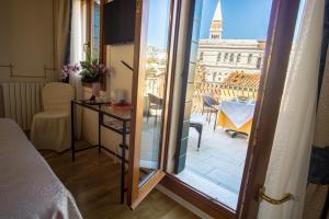 a room with a balcony with a view of a building at Hotel Antigo Trovatore in Venice