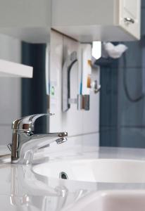 a bathroom sink with a faucet and a mirror at Hotel Vier Löwen in Traben-Trarbach