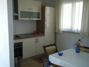 a small kitchen with a table and a white kitchen at Apartment Villa Green Court in Korčula