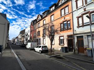 una calle de la ciudad con coches aparcados en la calle en # Le 3 # Joli appartement T3 Mulhouse centre, Neuf, calme et tout équipé en Mulhouse
