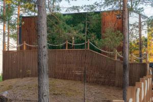 uma gaiola de rebatidas com uma cerca e árvores em Santalahti Resort Cottages & Villas em Kotka