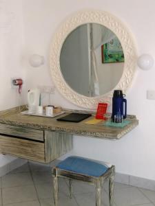 einen Schminktisch mit einem Spiegel und einem Stuhl in der Unterkunft Turtle Bay Beach Club in Watamu