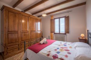 a bedroom with a large bed with wooden cabinets at La Zia Marisa in Montepulciano