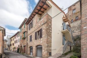 an old brick building with stairs on a street at La Zia Marisa in Montepulciano
