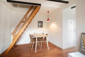 een eetkamer met een tafel en stoelen en een trap bij Hello Zeeland - Vakantiehuis Beatrixstraat 27A in Domburg