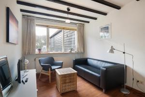 ein Wohnzimmer mit einem Sofa und einem TV in der Unterkunft Hello Zeeland - Vakantiehuis Beatrixstraat 27A in Domburg