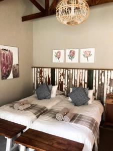 een slaapkamer met 2 bedden en een kroonluchter bij Anderland - De Oude Melkstal in Potchefstroom