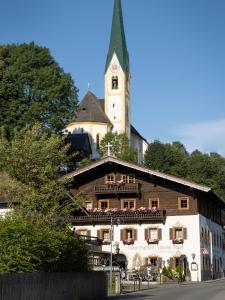 ein Gebäude mit einem Uhrturm darüber in der Unterkunft Alpen Glück Hotel Unterm Rain garni in Kirchberg in Tirol