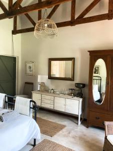 een slaapkamer met een bed, een spiegel en een dressoir bij Anderland - De Oude Melkstal in Potchefstroom