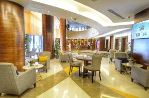 فندق روف جدة في جدة: مطعم فيه طاولات وكراسي في لوبي