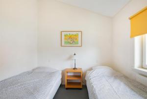 een slaapkamer met 2 bedden en een tafel met een lamp bij Hello Zeeland - Appartement Beatrixstraat 27 in Domburg
