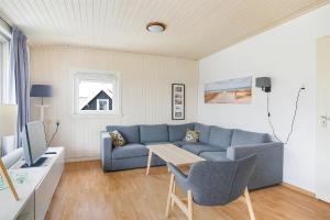 a living room with a blue couch and a table at Hello Zeeland - Appartement Beatrixstraat 27 in Domburg