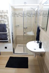 een badkamer met een wastafel en een glazen douche bij Ubytování Česká Kanada in Kunžak