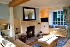 a living room with a couch and a fireplace at Charming Cottage, Great Rissington, Cotswolds in Great Rissington