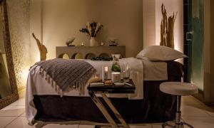 a bedroom with a bed with a table and a stool at Alexander House Hotel & Utopia Spa in Turners Hill