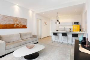 a living room with a couch and a kitchen at Chic 1BR in White City by HolyGuest in Tel Aviv