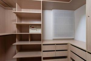 a walk in closet with wooden shelves and a window at Chic 1BR in White City by HolyGuest in Tel Aviv