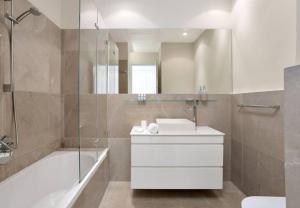 ein Bad mit einer Badewanne, einem Waschbecken und einer Dusche in der Unterkunft Chic 1BR in White City by HolyGuest in Tel Aviv