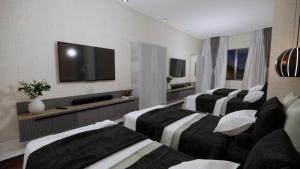a hotel room with four beds and a flat screen tv at iNALENS AİRPORT KONAKLAMA in Arnavutköy