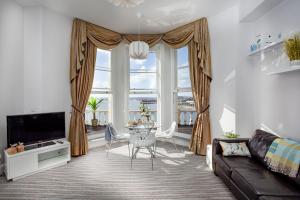 un soggiorno con tavolo e una grande finestra di Sea-la-vie, Astor House a Torquay