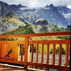 a wooden deck with a view of mountains at Esprit de la Meije - Chalet overlooking the Meije in La Grave