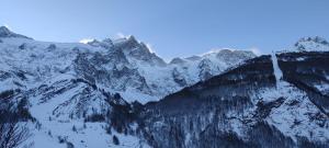 a mountain covered in snow with trees on it at Esprit de la Meije - Chalet overlooking the Meije in La Grave