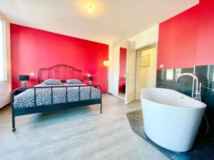um quarto vermelho com uma cama e uma banheira em COLMAR - Appartements Deluxe - Lumineux - Stationnement Gratuit et Facile dans la rue em Colmar